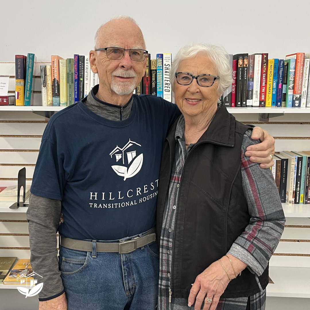 Two volunteers in front of the book section