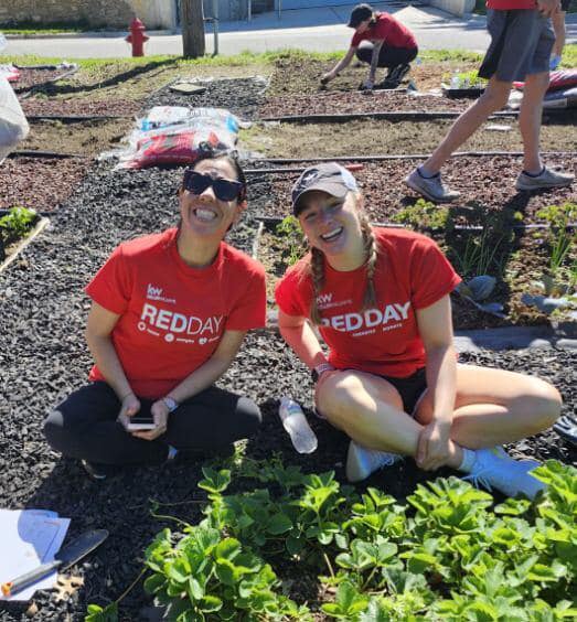 Two volunteers smiling in the garden